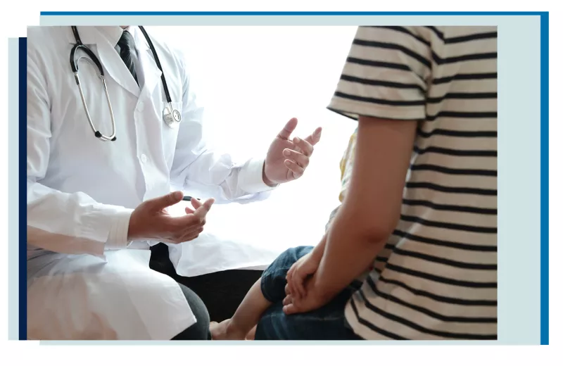 doctor in white coat speaking and gesturing to seated patient